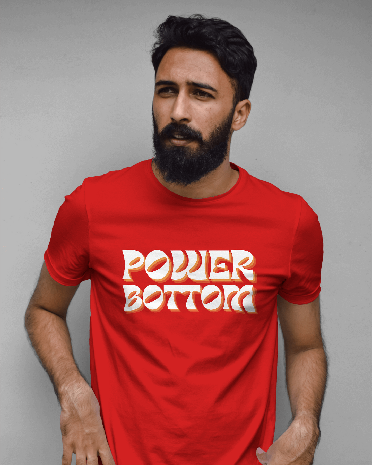 Man wearing a red t-shirt with 'POWER BOTTOM' text against a gray backgroundKink, LGBTQIA+, Queer Sub Dom