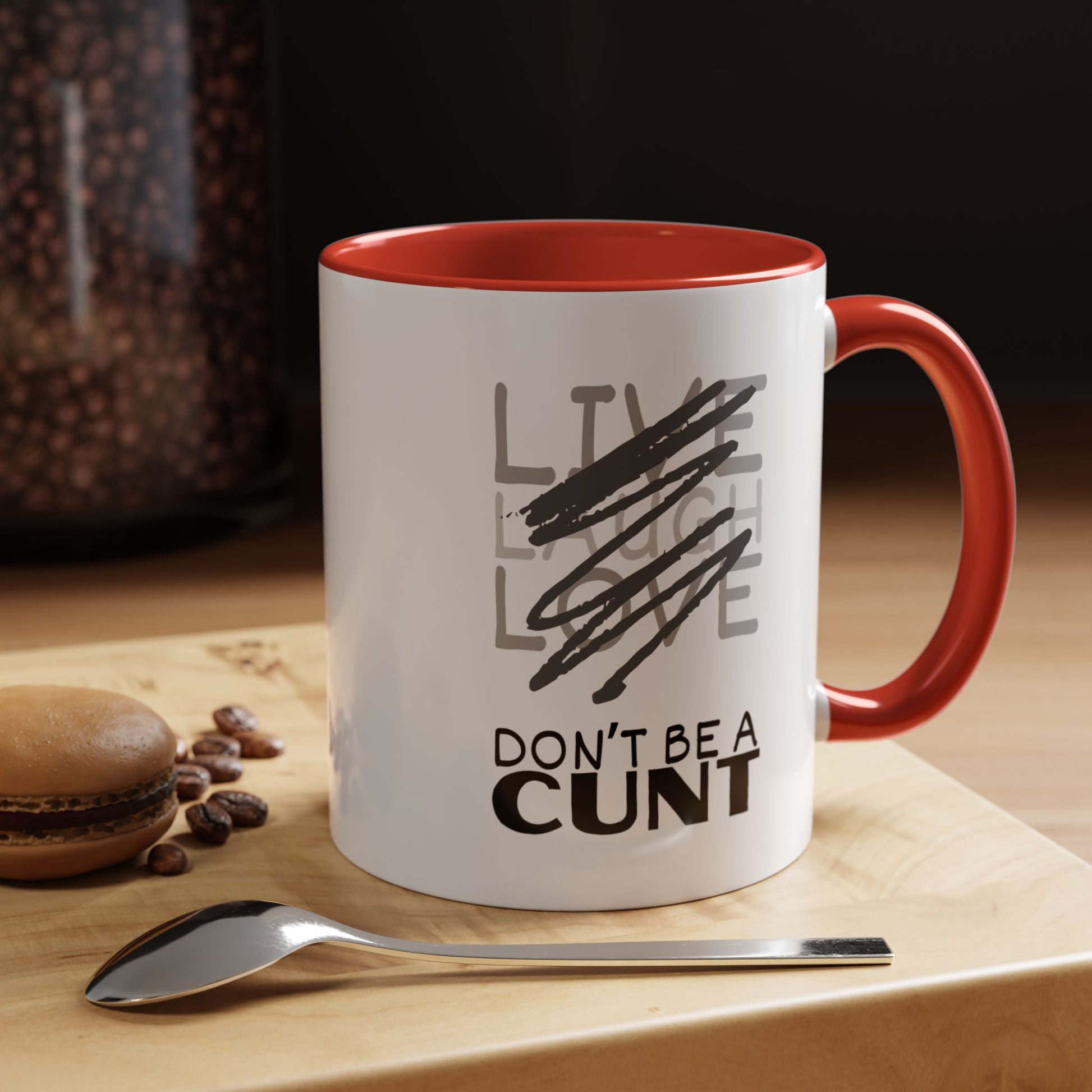 Mug with text on a table with coffee beans and a spoon
