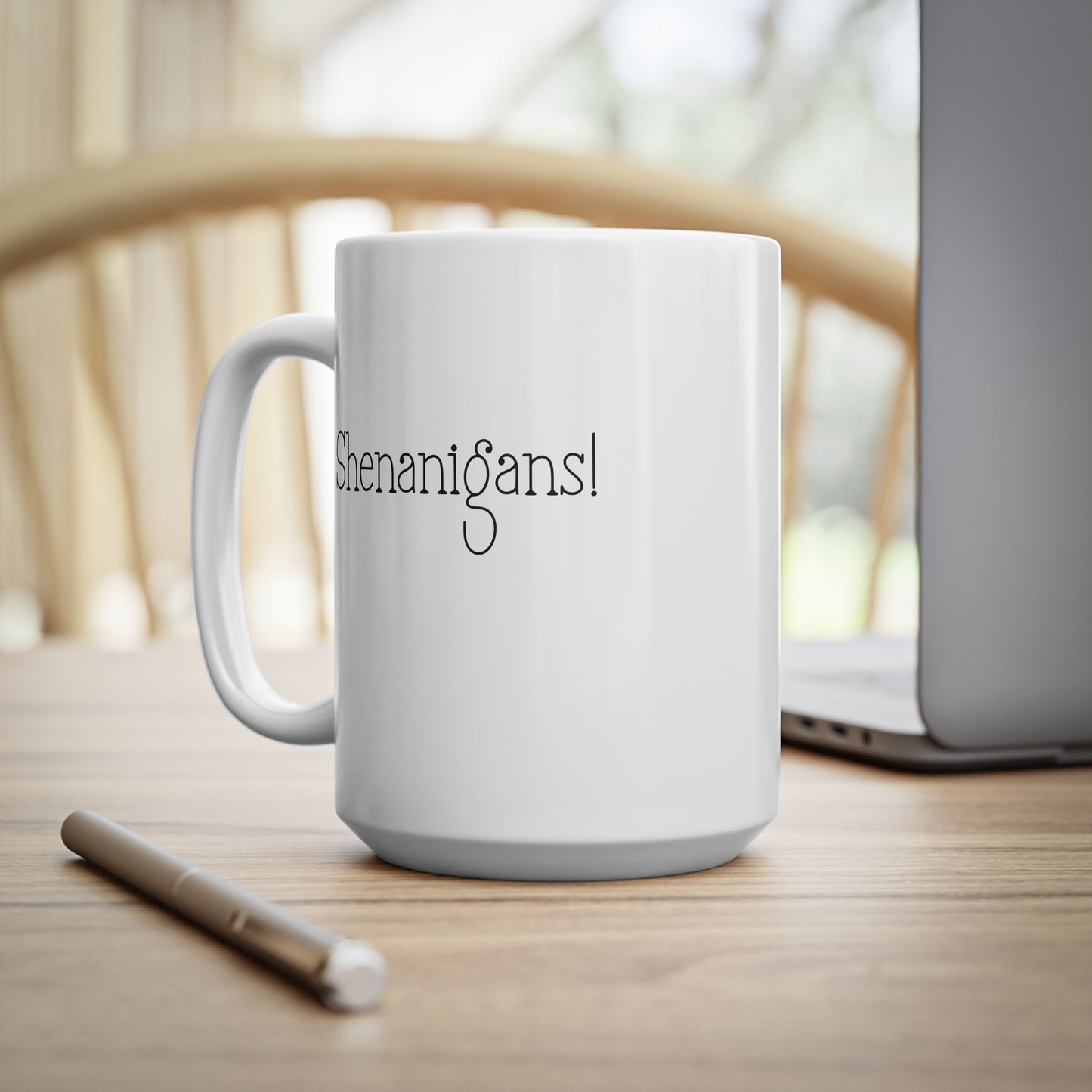 White mug with 'Shenanigans!' text on a wooden surface