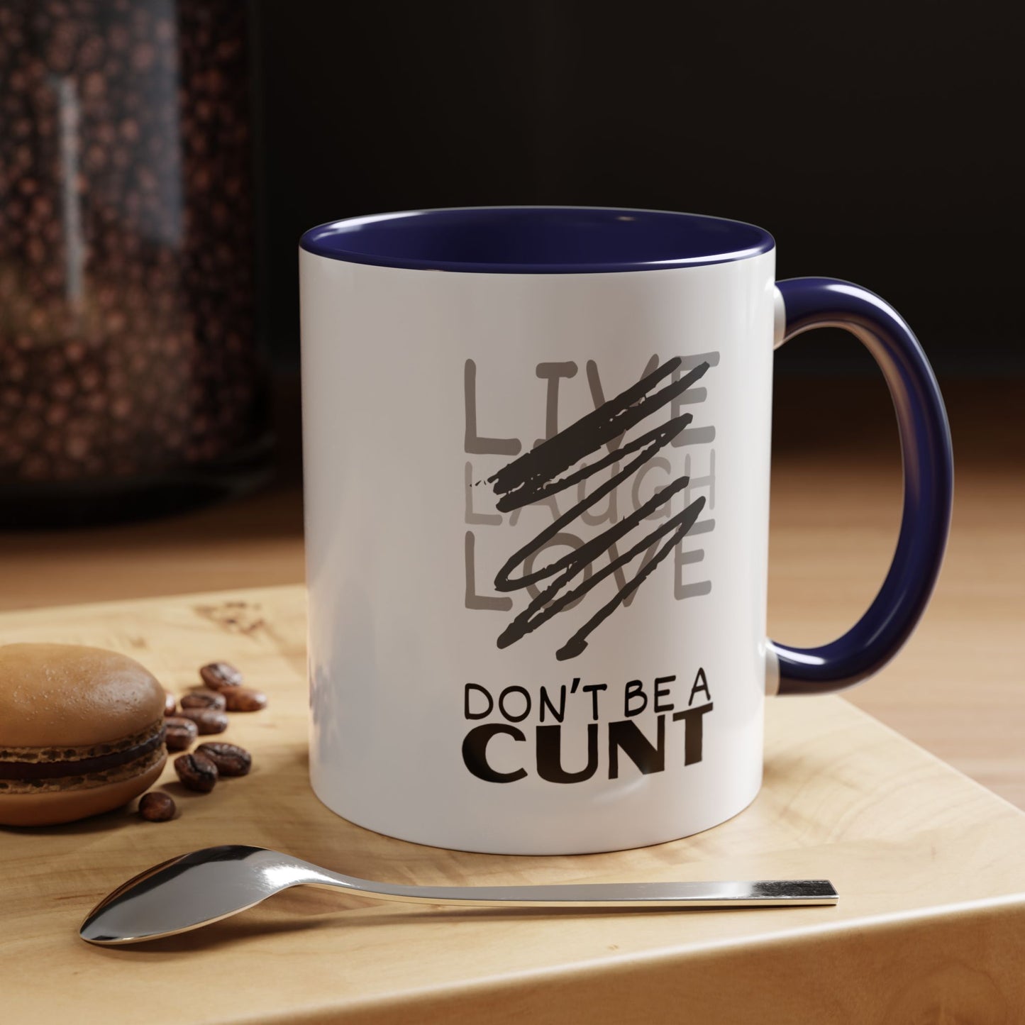 Mug with text on a wooden surface with coffee beans and a spoon