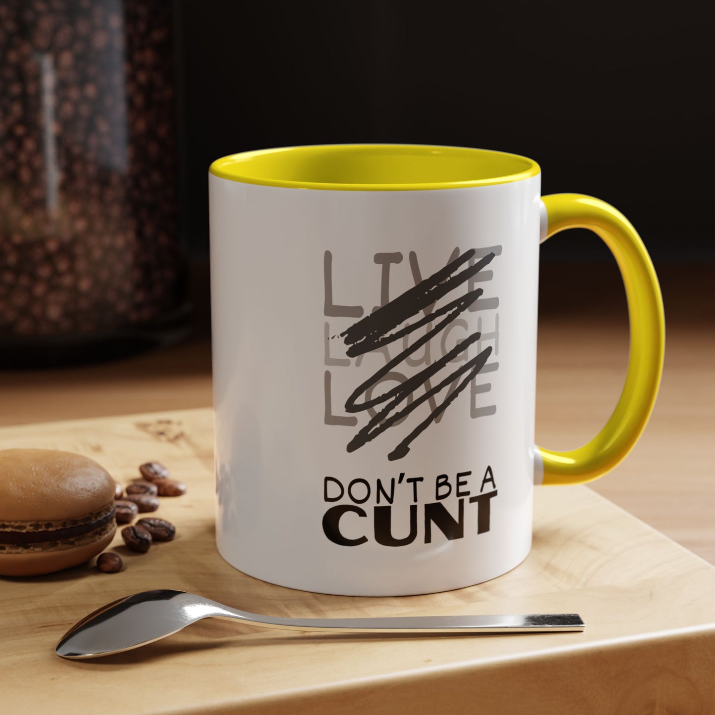 Mug with text on a wooden surface with coffee beans and a spoon