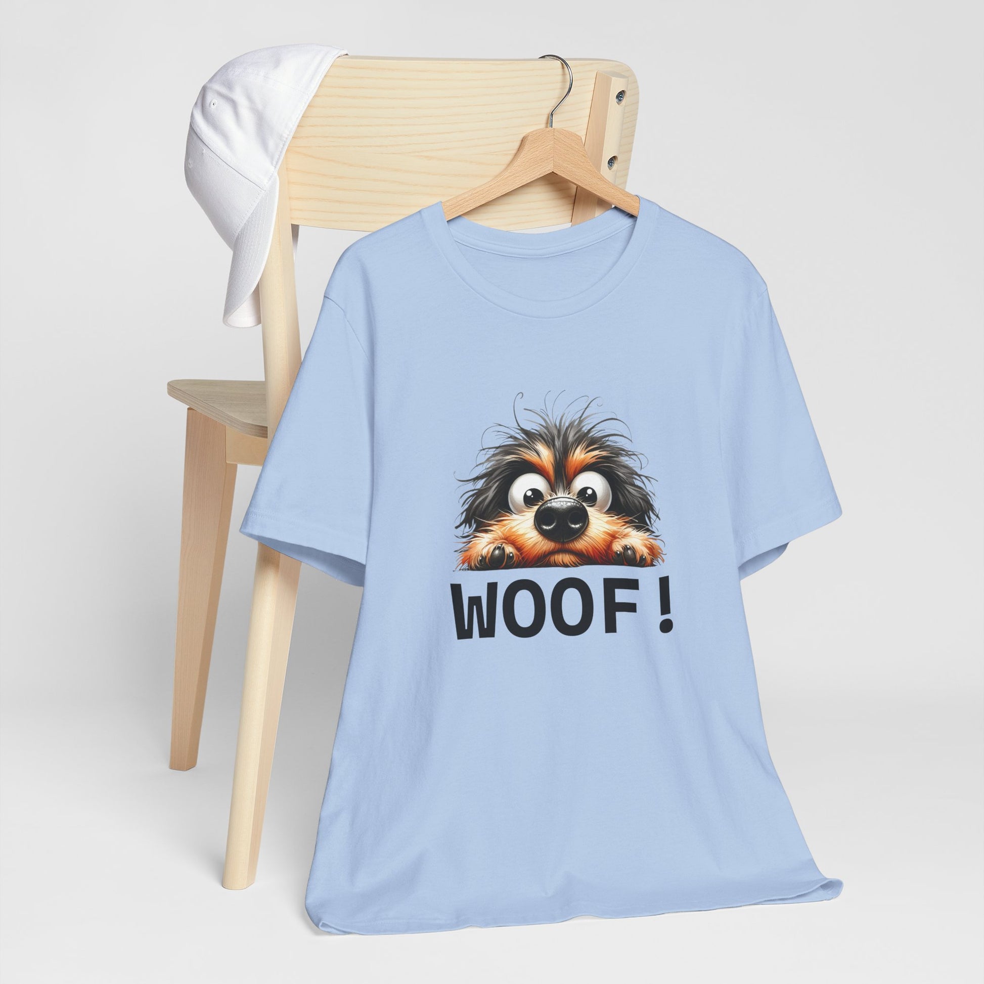 Light blue t-shirt with a dog graphic and 'WOOF!' text on a wooden chair.