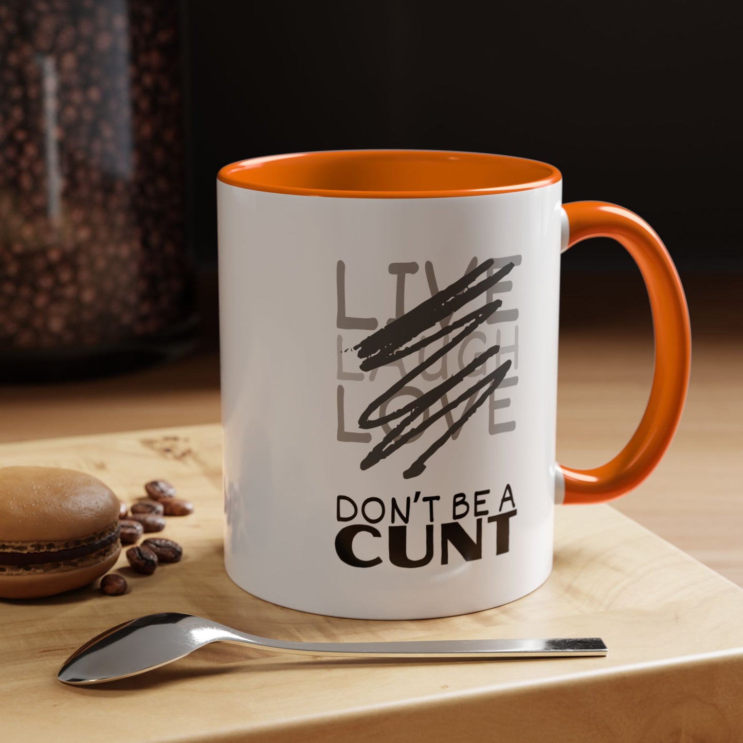 Mug with text on a table with coffee beans and a spoon