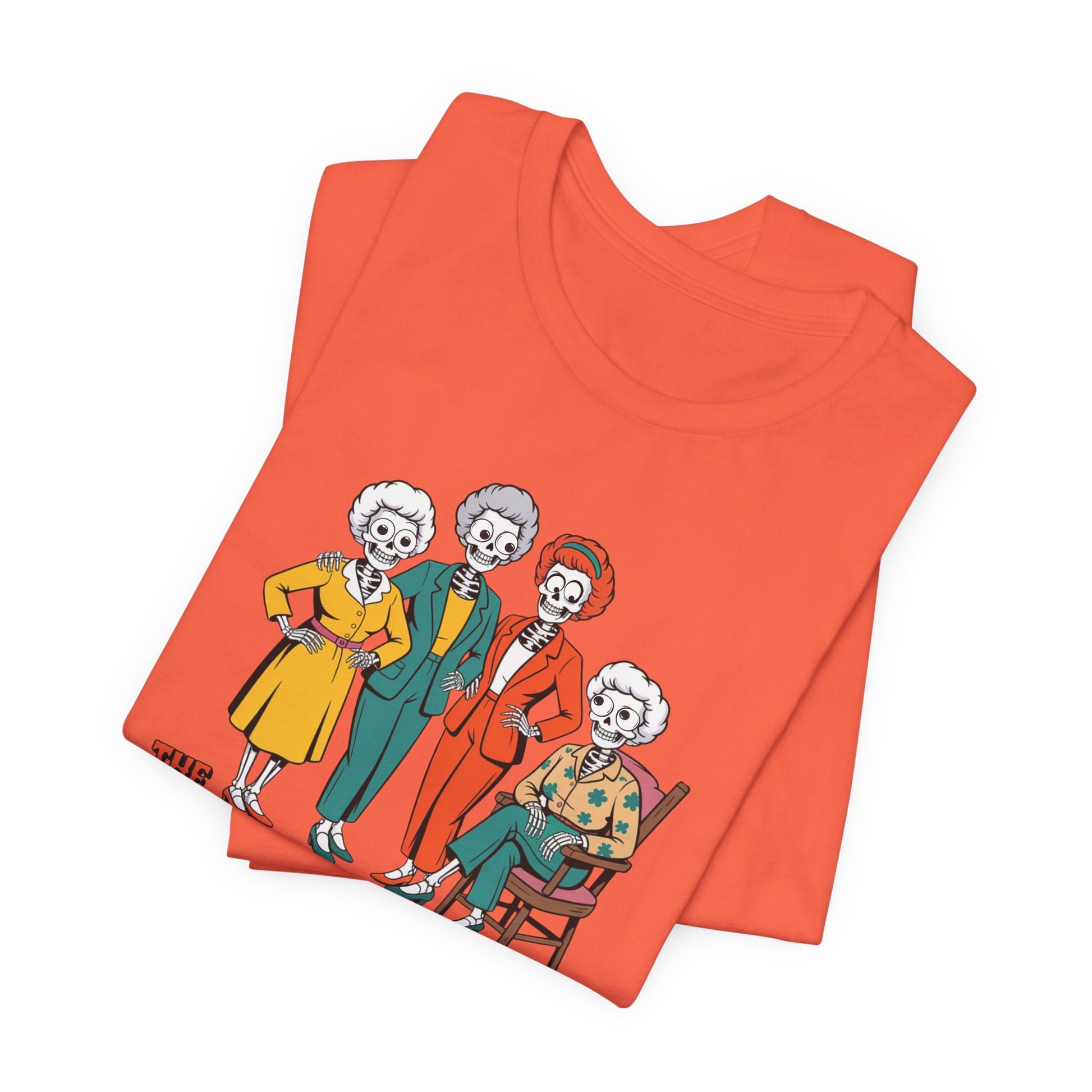 Folded orange t-shirt with cartoon skeleton design on a white background   Golden Girls, 80s TV, Halloween Tees