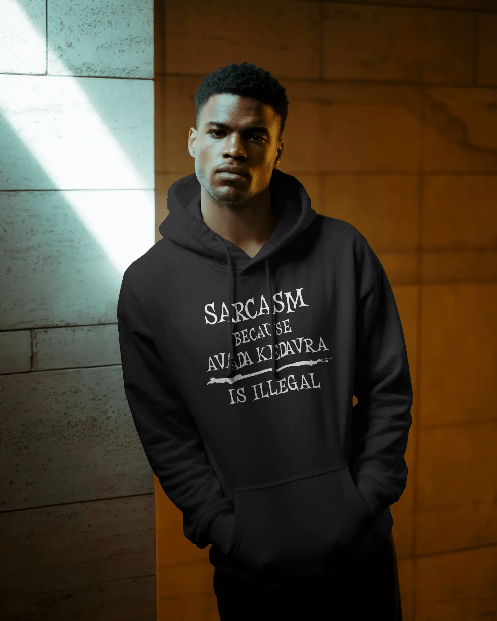 Person wearing a black hoodie with text, standing against a textured wall.  Sarcasm, Sarcastic Humor, Harry Potter, potterhead, avada kedavra