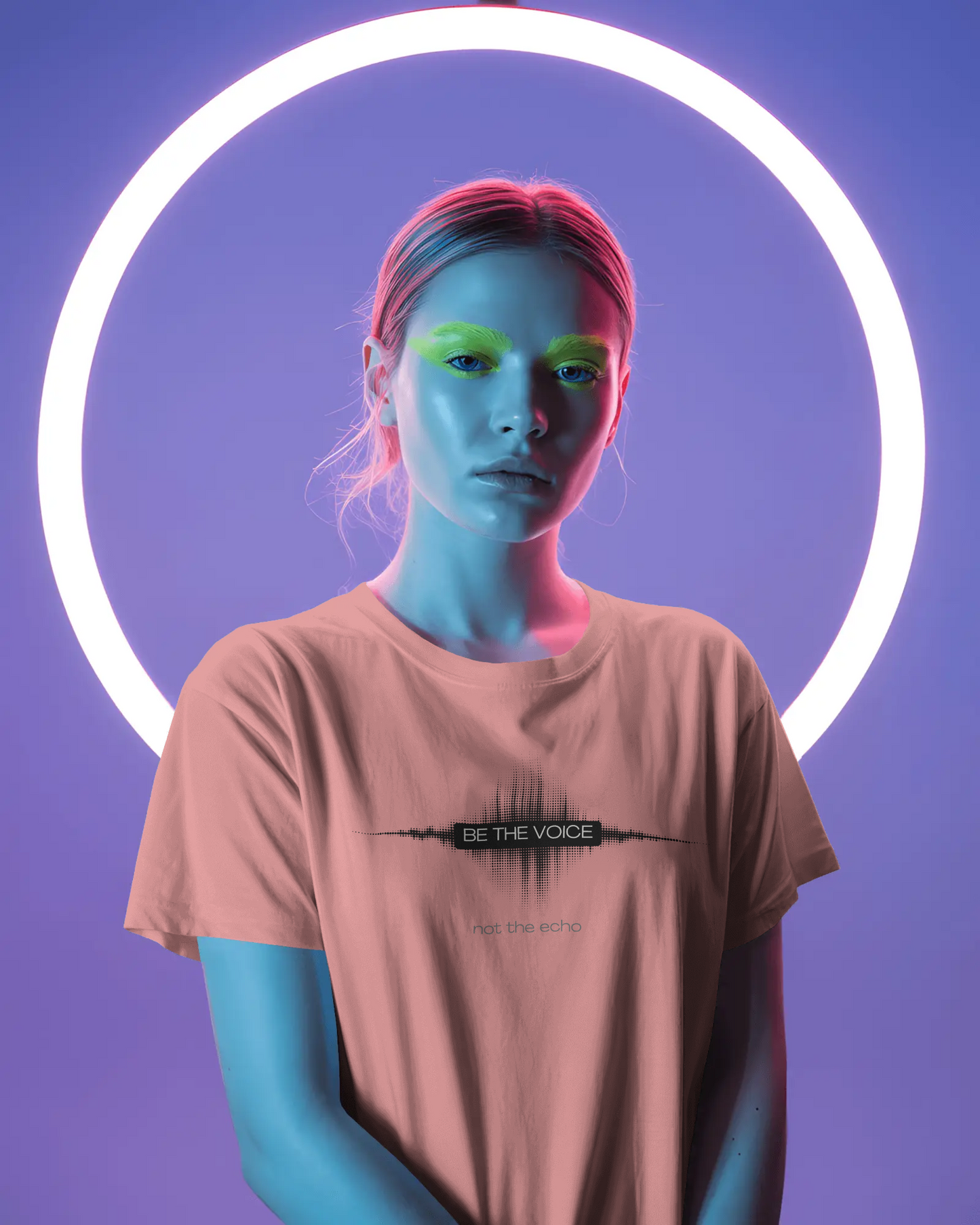 Person wearing a t-shirt with 'Be the Voice' text in a neon-lit setting