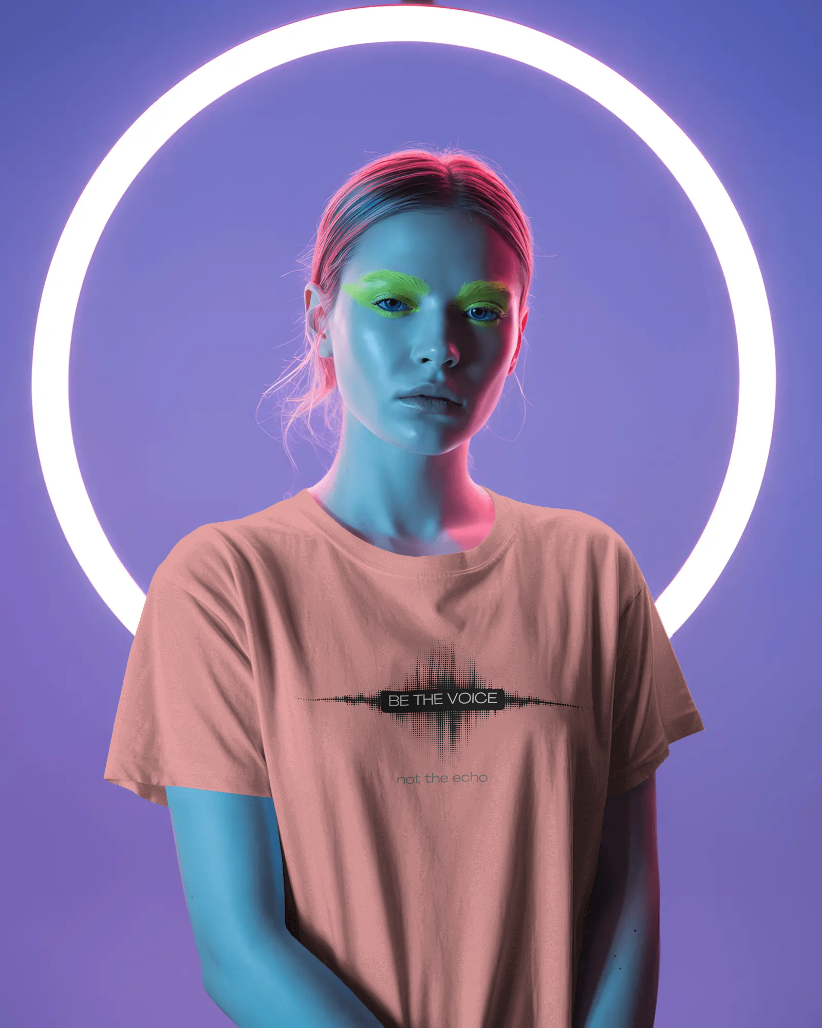 Person wearing a t-shirt with 'Be the Voice' text in a neon-lit setting