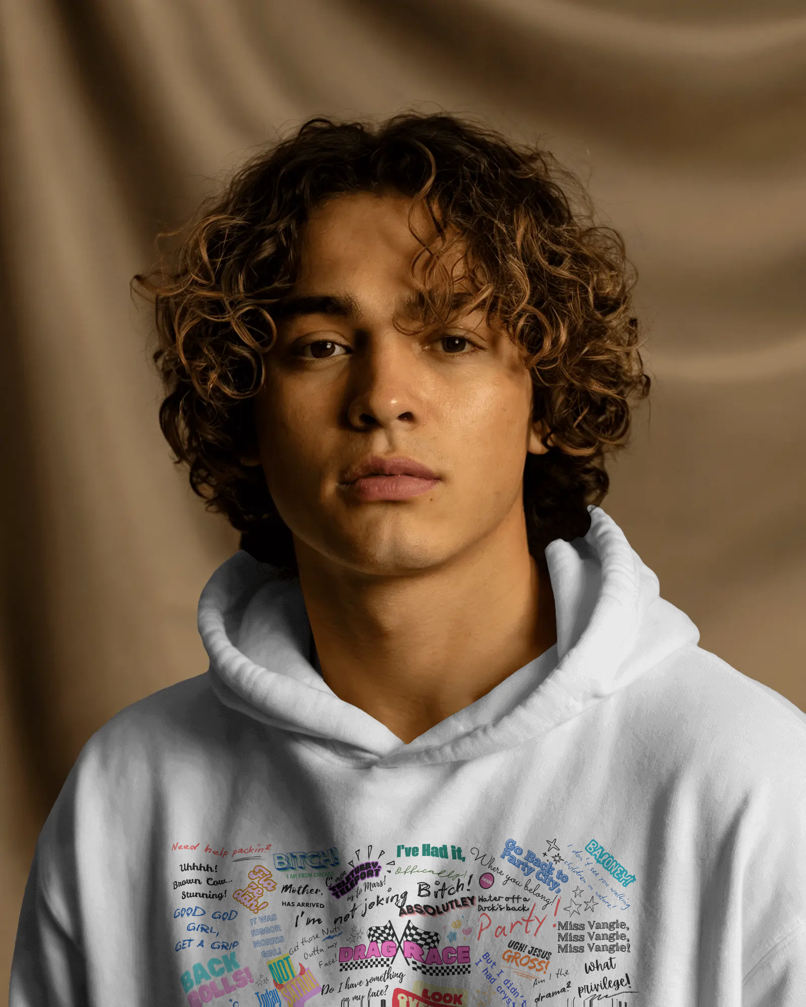Person wearing a white hoodie with colorful text design against a brown background  Drag race, Rupaul, Rupaul's Drag Race UK, LGBT, Queer Culture, Gay, Drag Queen