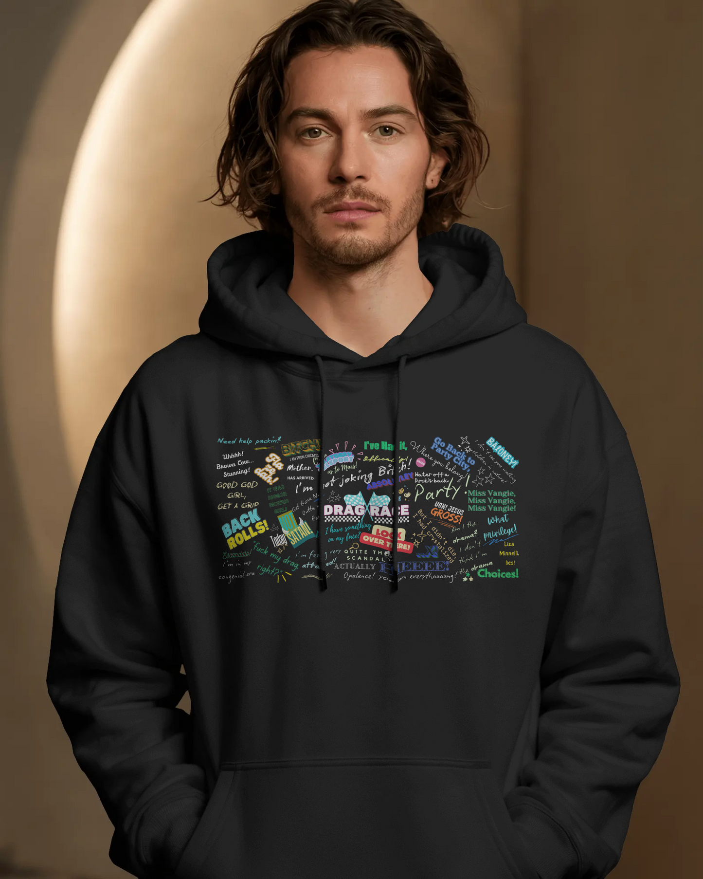Man wearing a black hoodie with colorful graphic design on a brown background  Drag race, Rupaul, Rupaul's Drag Race UK, LGBT, Queer Culture, Gay, Drag Queen