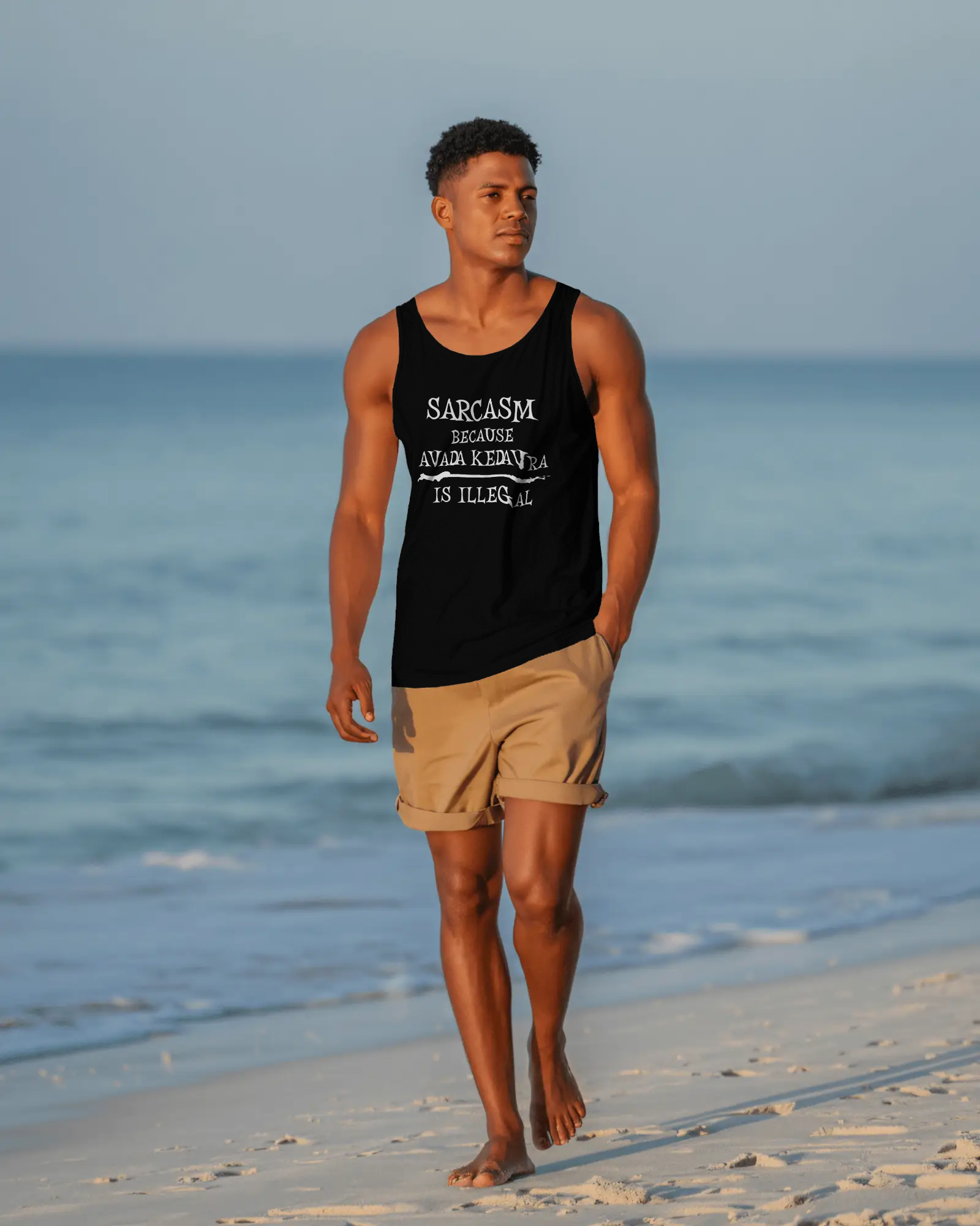 Man walking on a beach wearing a black tank top with text and beige shorts. Sarcasm, Sarcastic Humor, Harry Potter, Potter head, Avada Kedavra Sarcasm, Sarcastic Humor, Harry Potter, Potter head, Avada Kedavra
