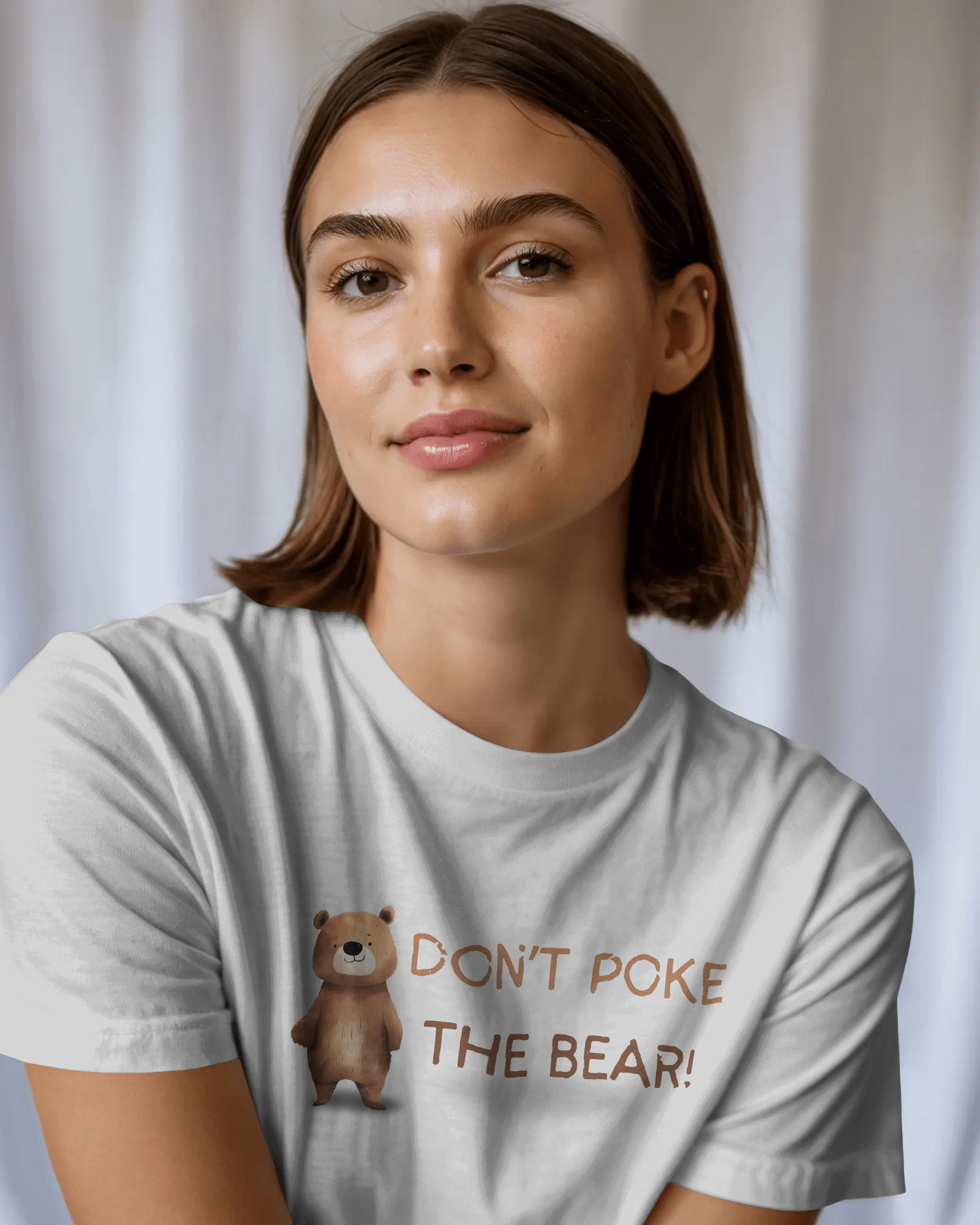 Woman wearing a t-shirt with a bear graphic and text against a plain background