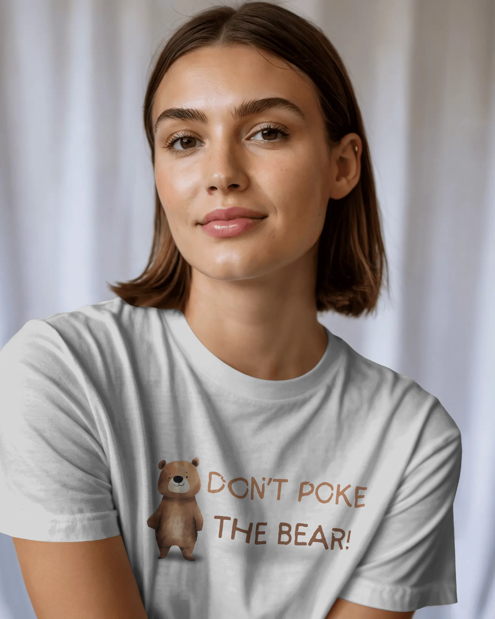 Woman wearing a t-shirt with a bear graphic and text against a plain background