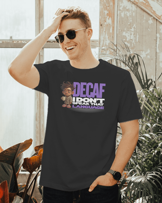 Man wearing a black t-shirt with a graphic and text, standing in a room with plants.
