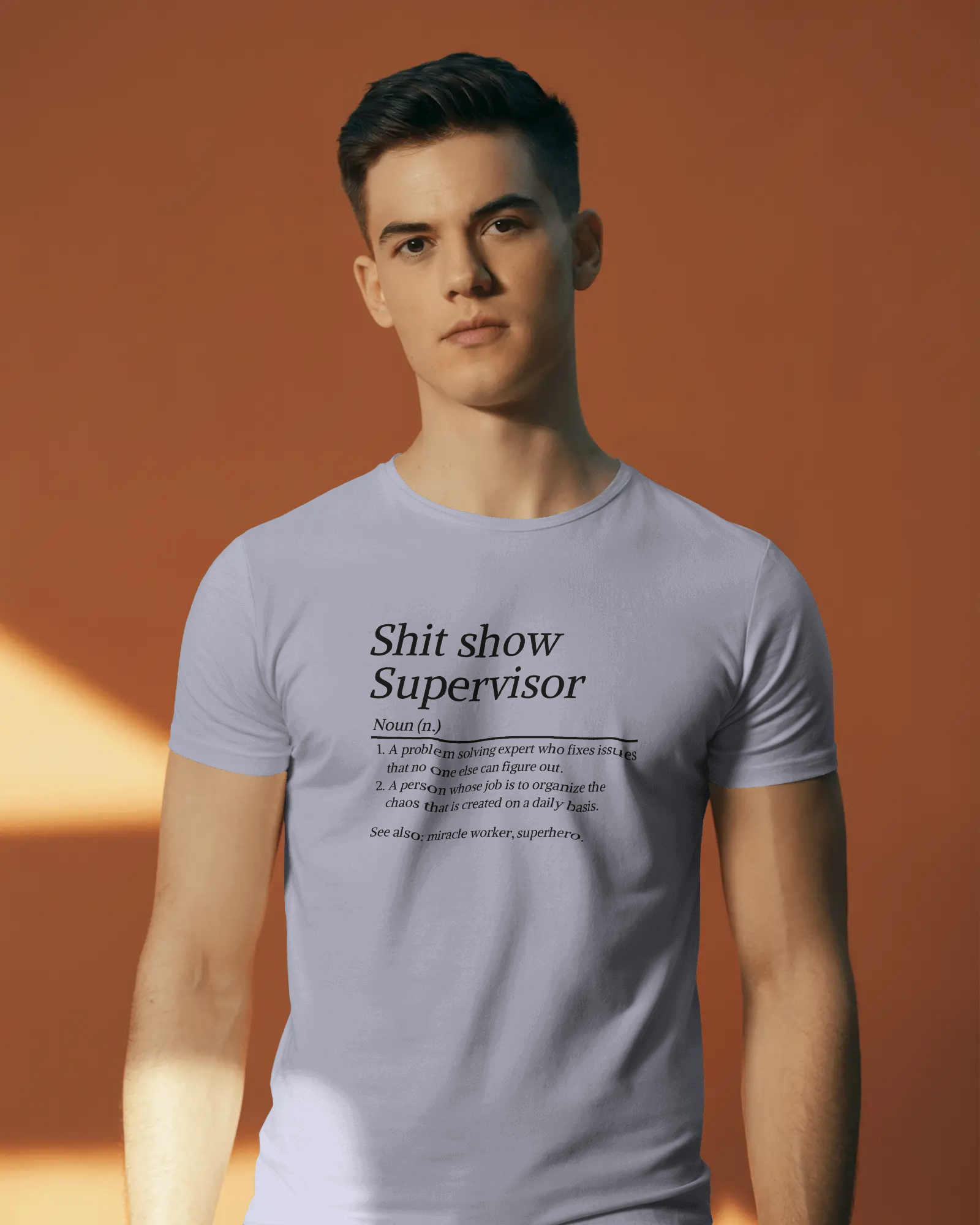 Man wearing a light gray t-shirt with text design against an orange background