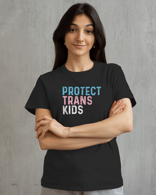 Person wearing a black t-shirt with 'PROTECT TRANS KIDS' text on a gray background