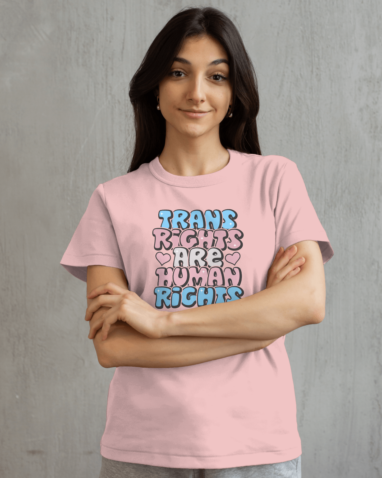 Person wearing a pink t-shirt with 'Trans Rights Are Human Rights' text on a gray background LGBTQIA+, Queer, Trans rights