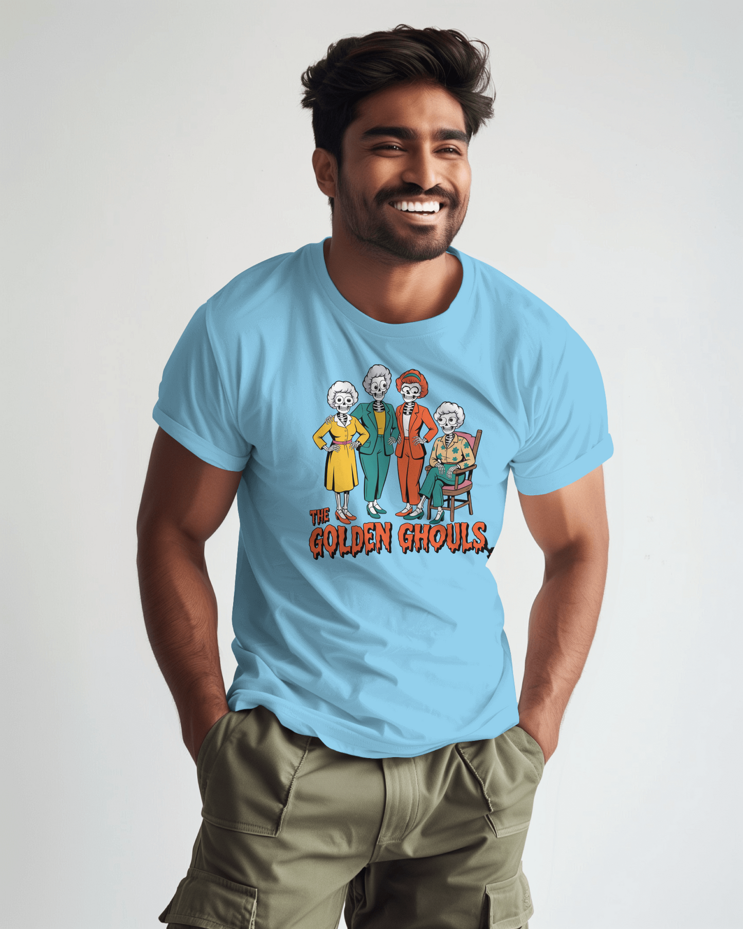 Man wearing a light blue t-shirt with 'The Golden Ghouls' graphic design on a plain background   Golden Girls, 80s TV, Halloween Tees