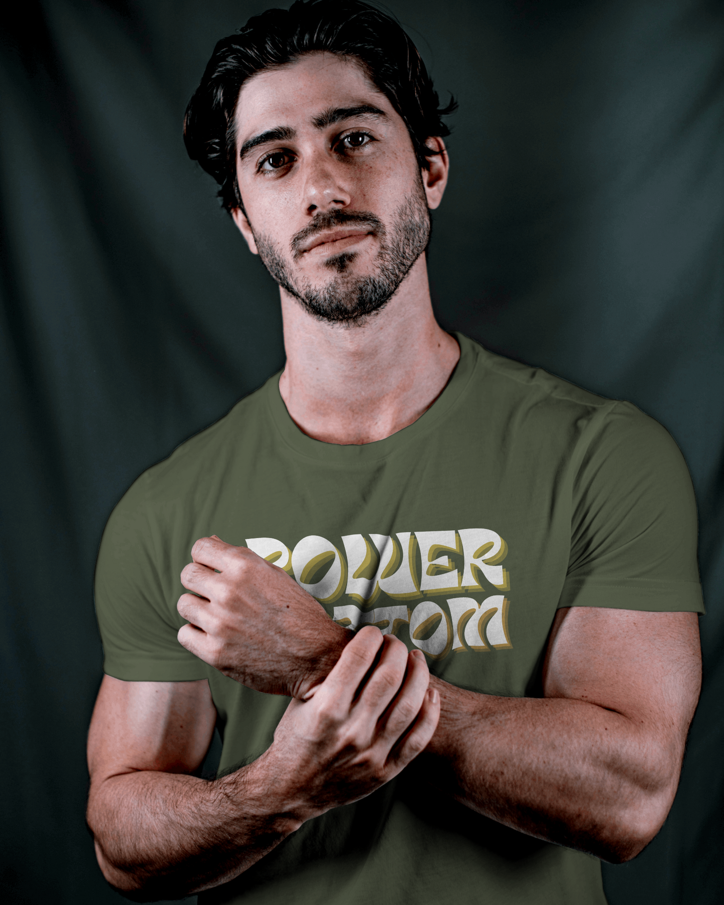 Man wearing a green t-shirt with 'POWER WORD' text against a dark backgroundKink, LGBTQIA+, Queer Sub Dom 