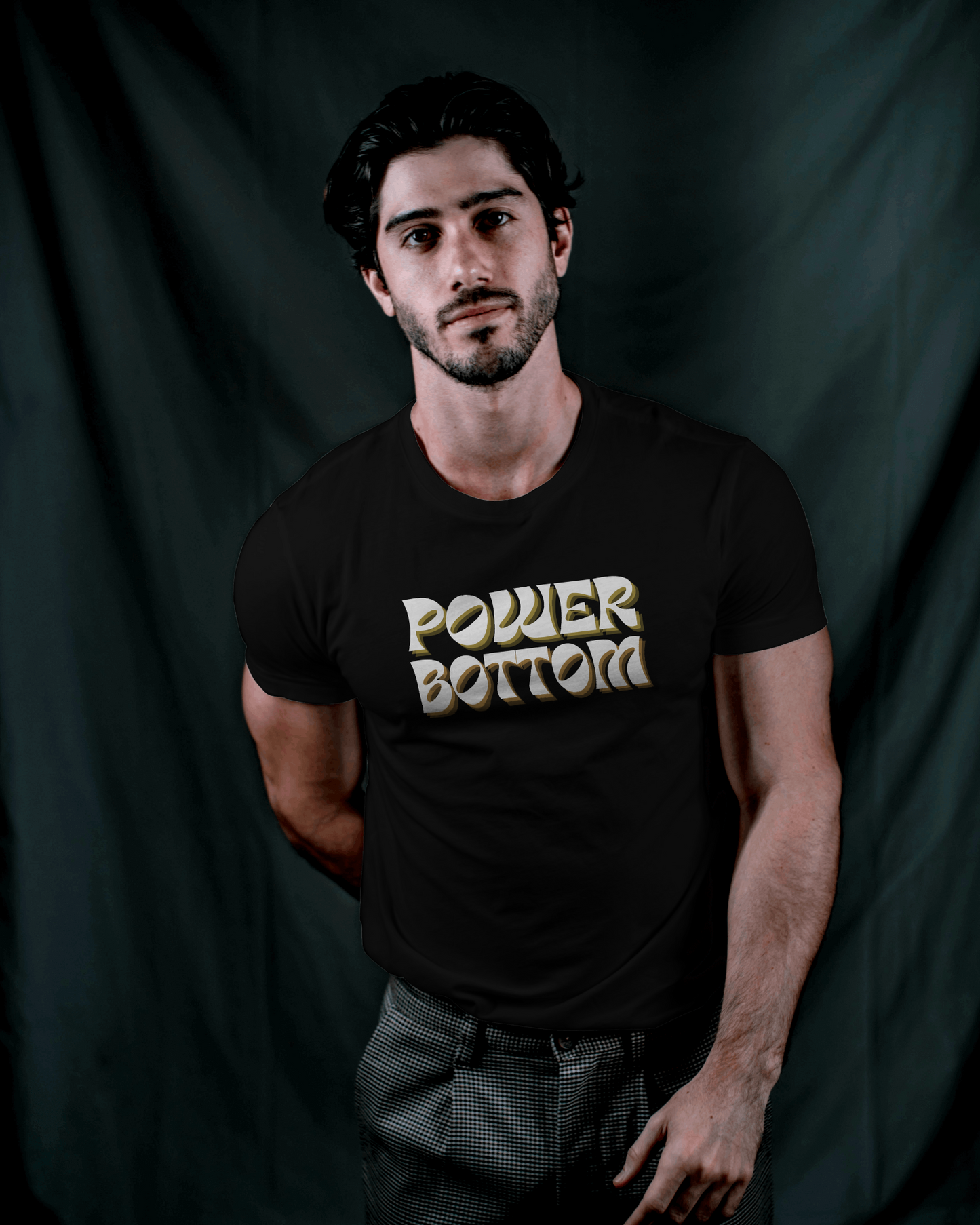 Man wearing a black t-shirt with 'POWER BOTTOM' text against a dark backgroundKink, LGBTQIA+, Queer Sub Dom 