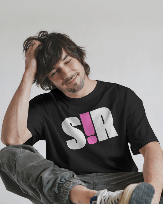 Man wearing a black t-shirt with 'S!R' printed on it, sitting against a plain background.  Kink, LGBTQIA+, Queer Sub Dom
