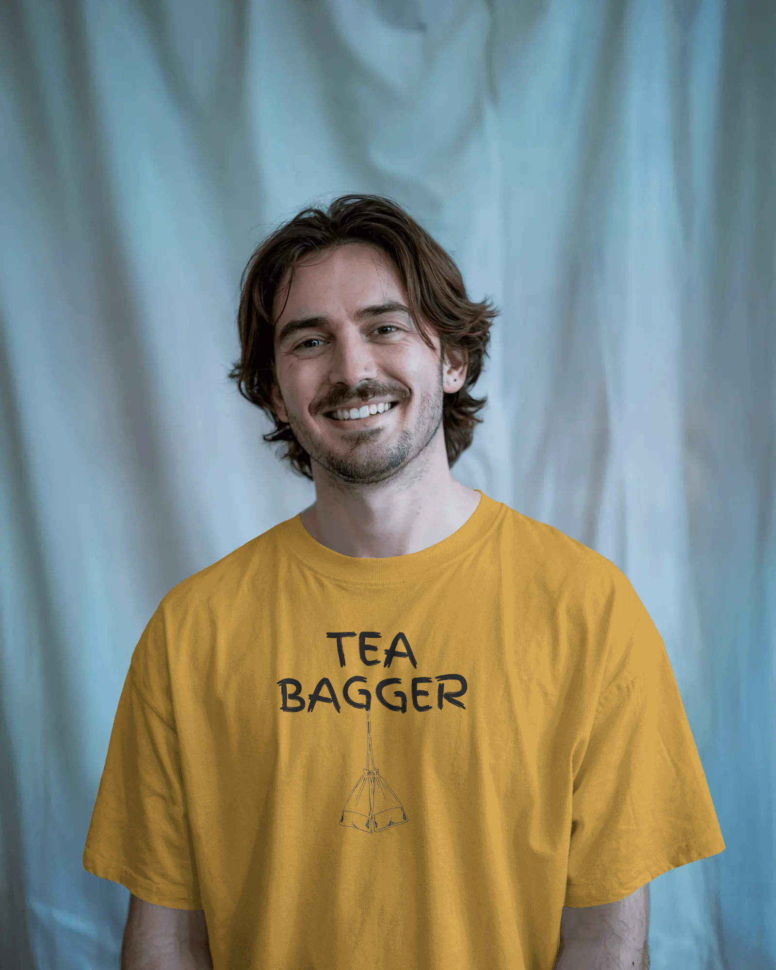 Man wearing a yellow t-shirt with 'TEA BAGGER' text against a plain background   Kink, LGBTQIA+, Queer