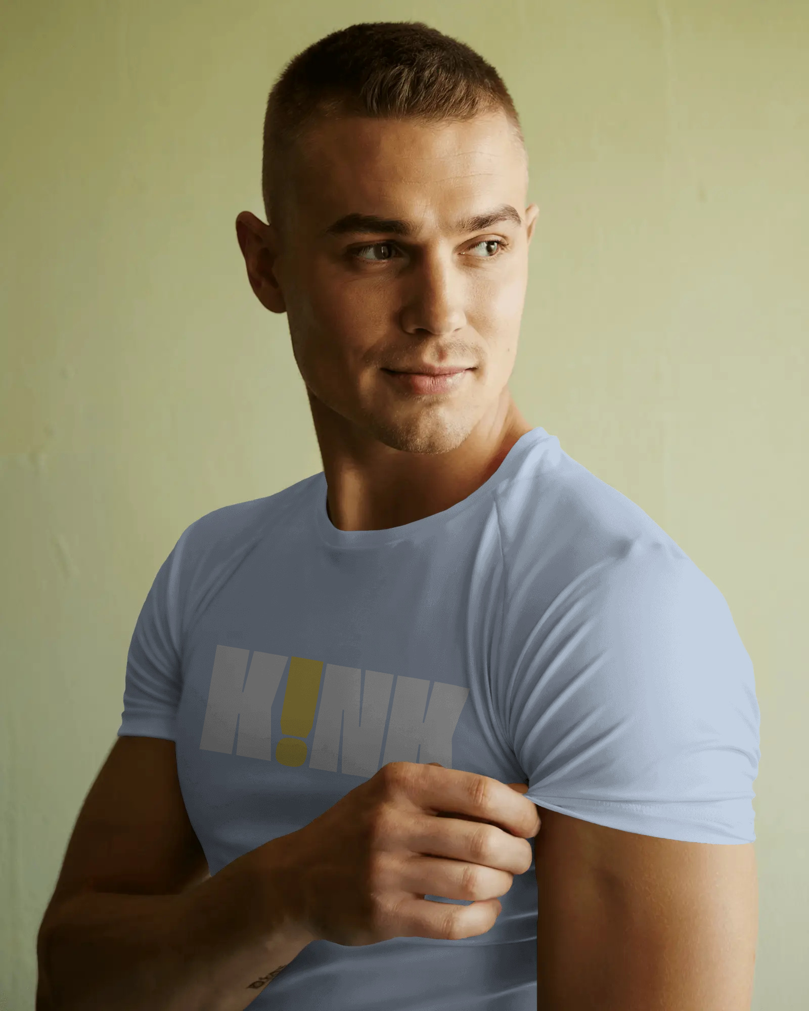 Man wearing a light blue t-shirt with a logo on a plain background   Kink, LGBTQIA+, Queer