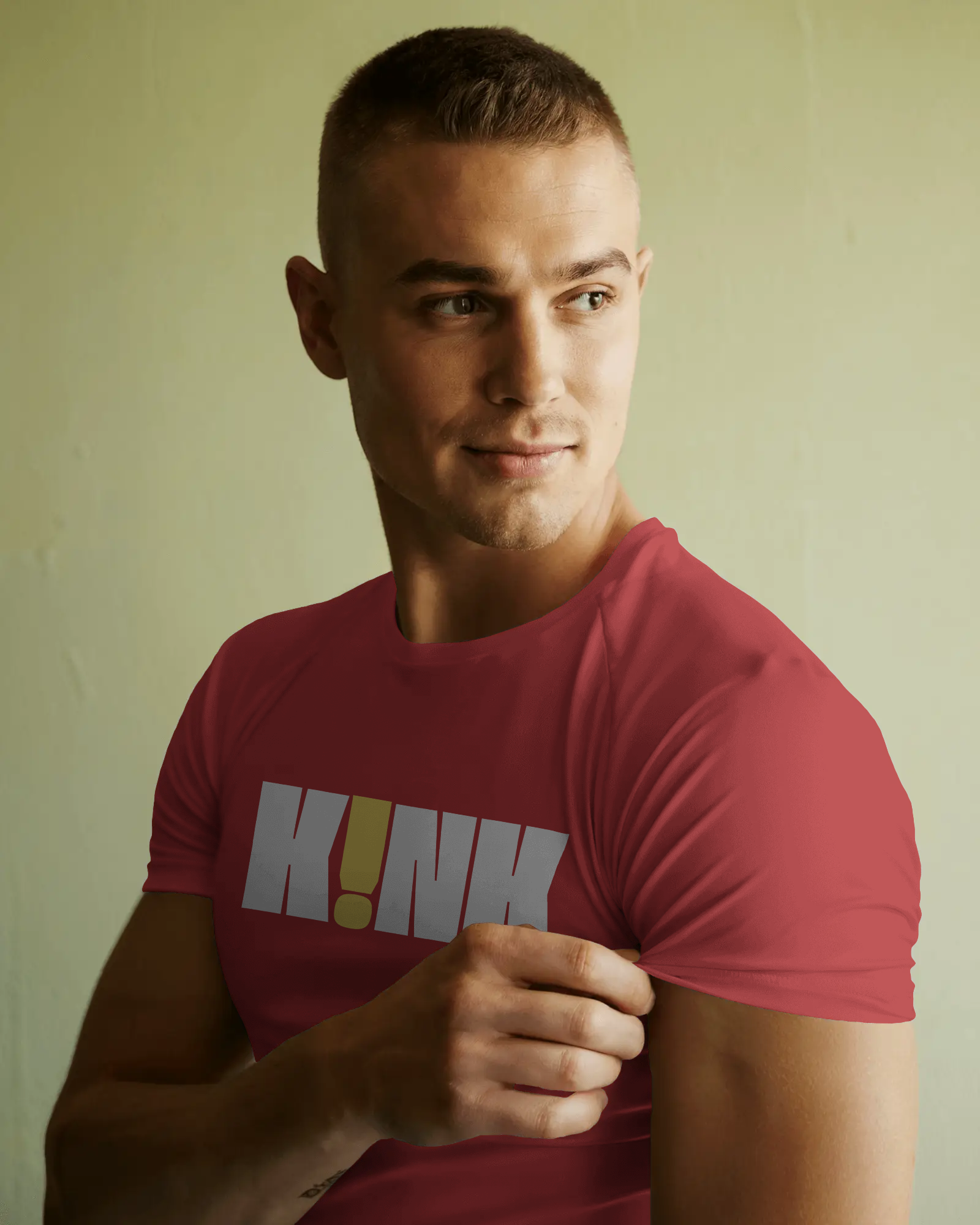 Man wearing a red t-shirt with a logo on a plain background  Kink, LGBTQIA+, Queer