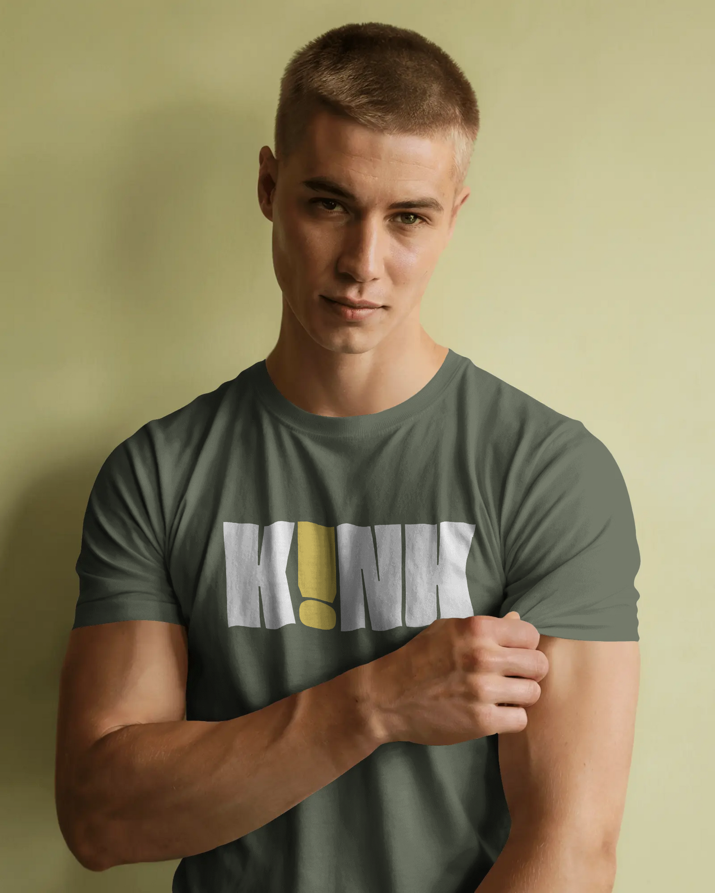 Man wearing a green t-shirt with a logo against a beige background  Kink, LGBTQIA+, Queer
