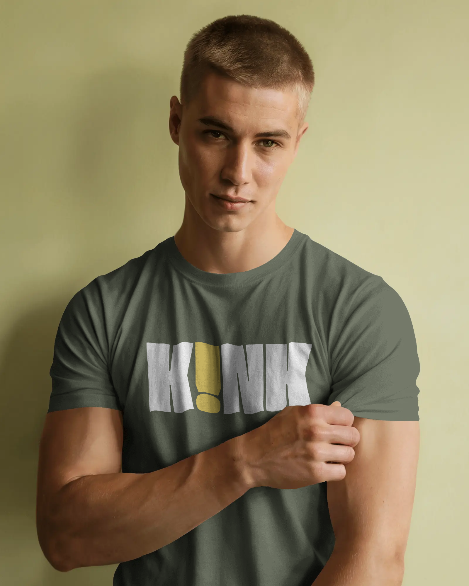 Man wearing a green t-shirt with a logo against a beige background  Kink, LGBTQIA+, Queer