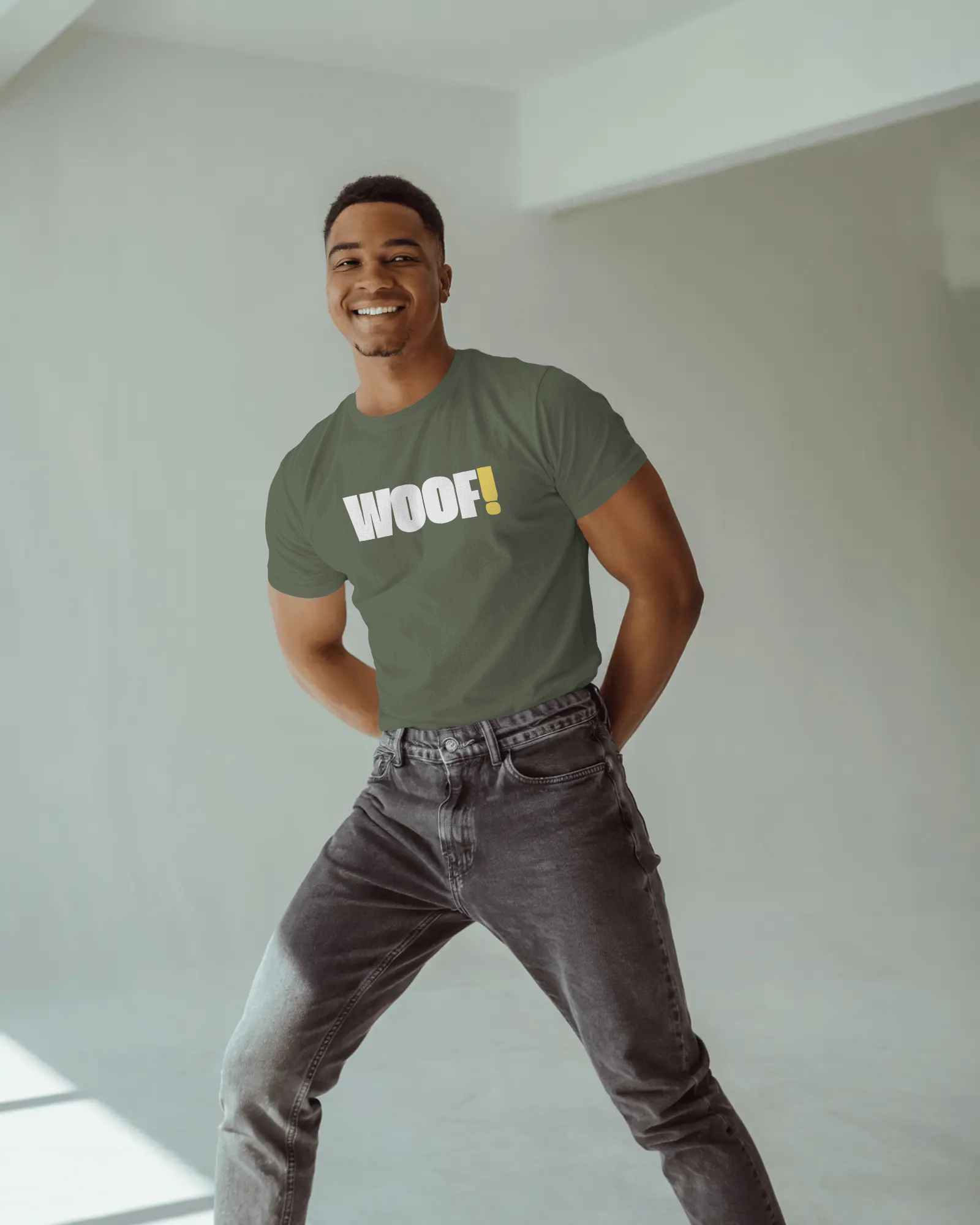 Man wearing a black t-shirt with 'WOOF!' text against a dark background LGBTQIA+ QUEER, Kink Positive
