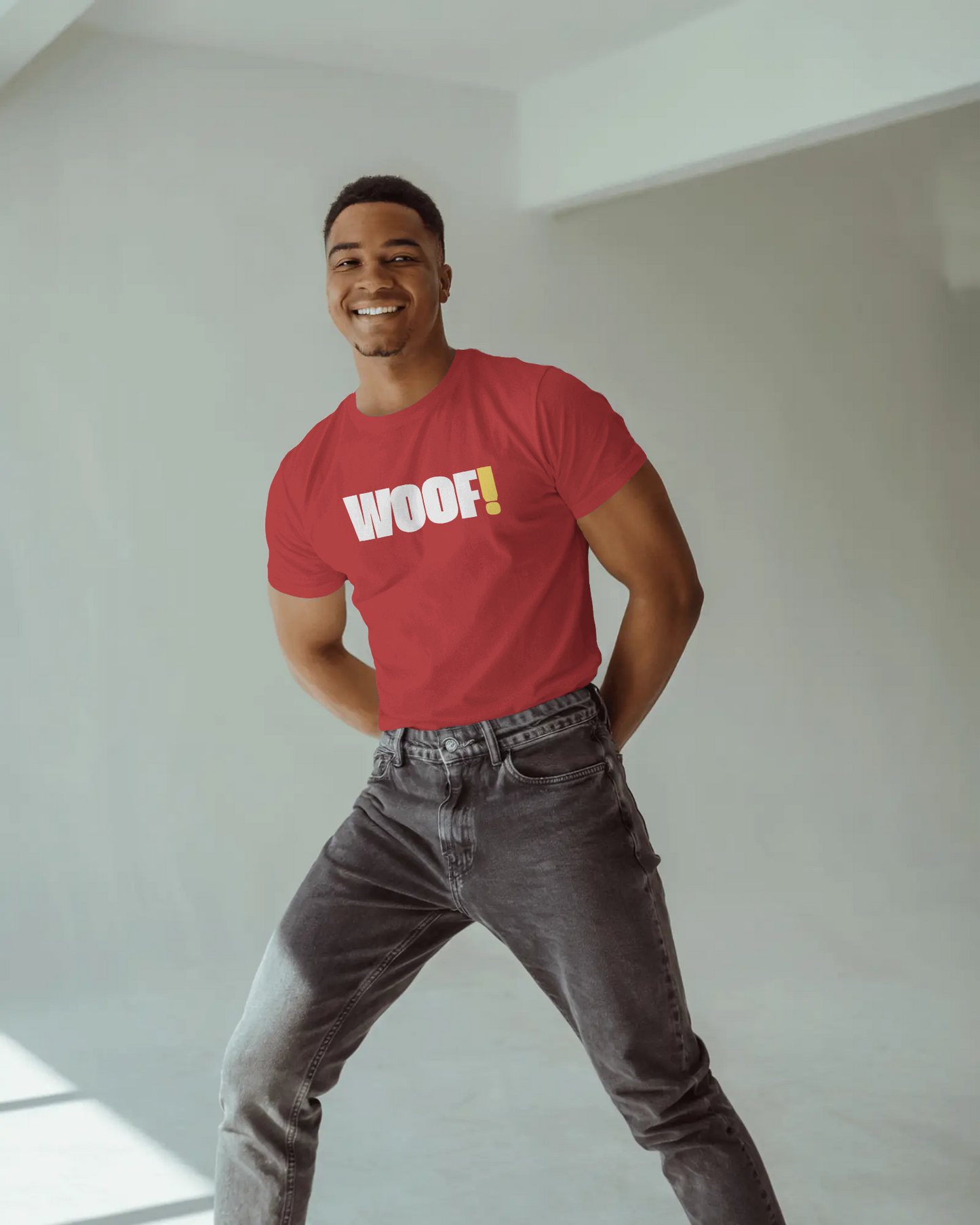 Man wearing a black t-shirt with 'WOOF!' text against a dark background LGBTQIA+ QUEER, Kink Positive