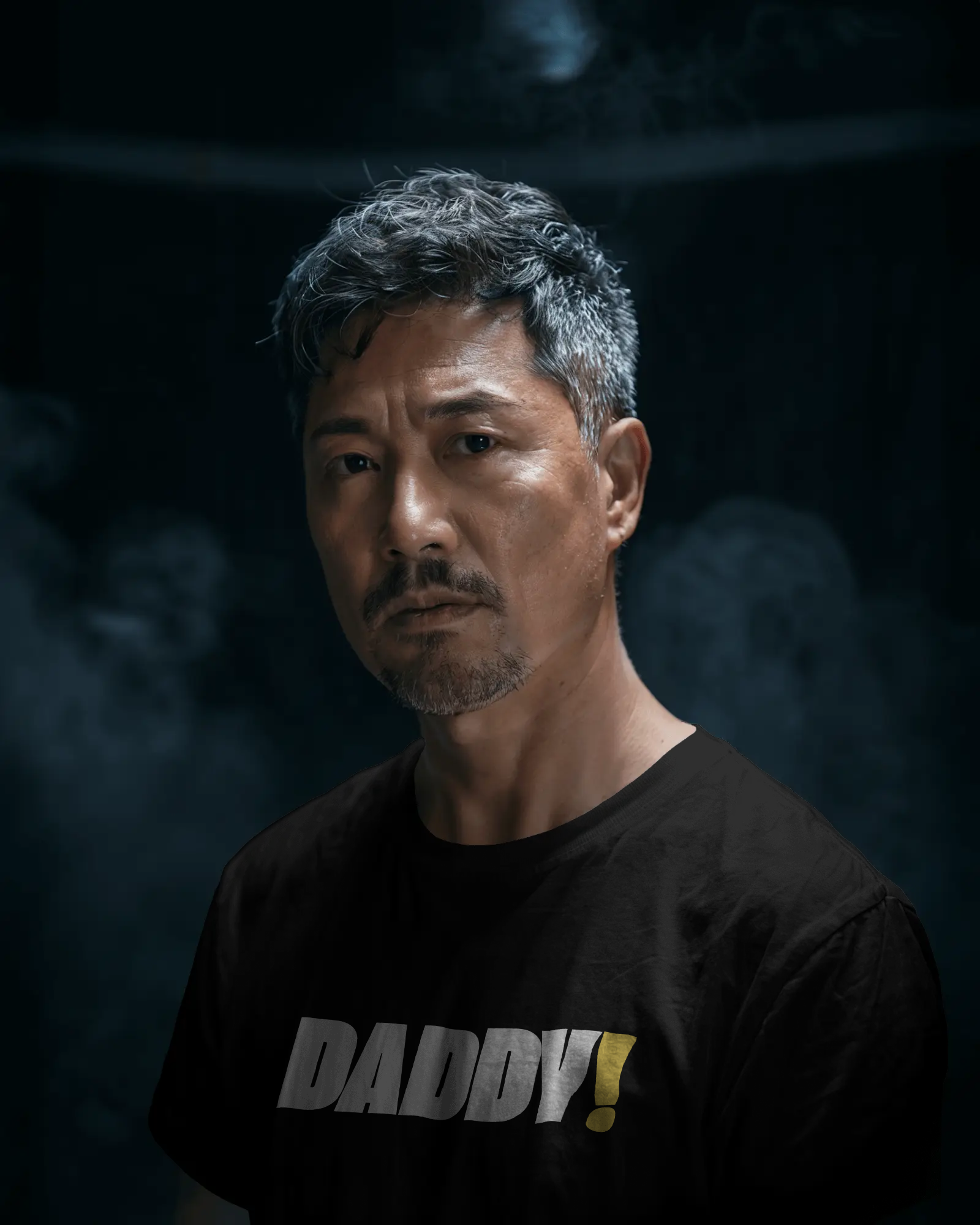 Man wearing a black t-shirt with 'DADDY!' text against a dark background LGBTQIA+ Kink Positive