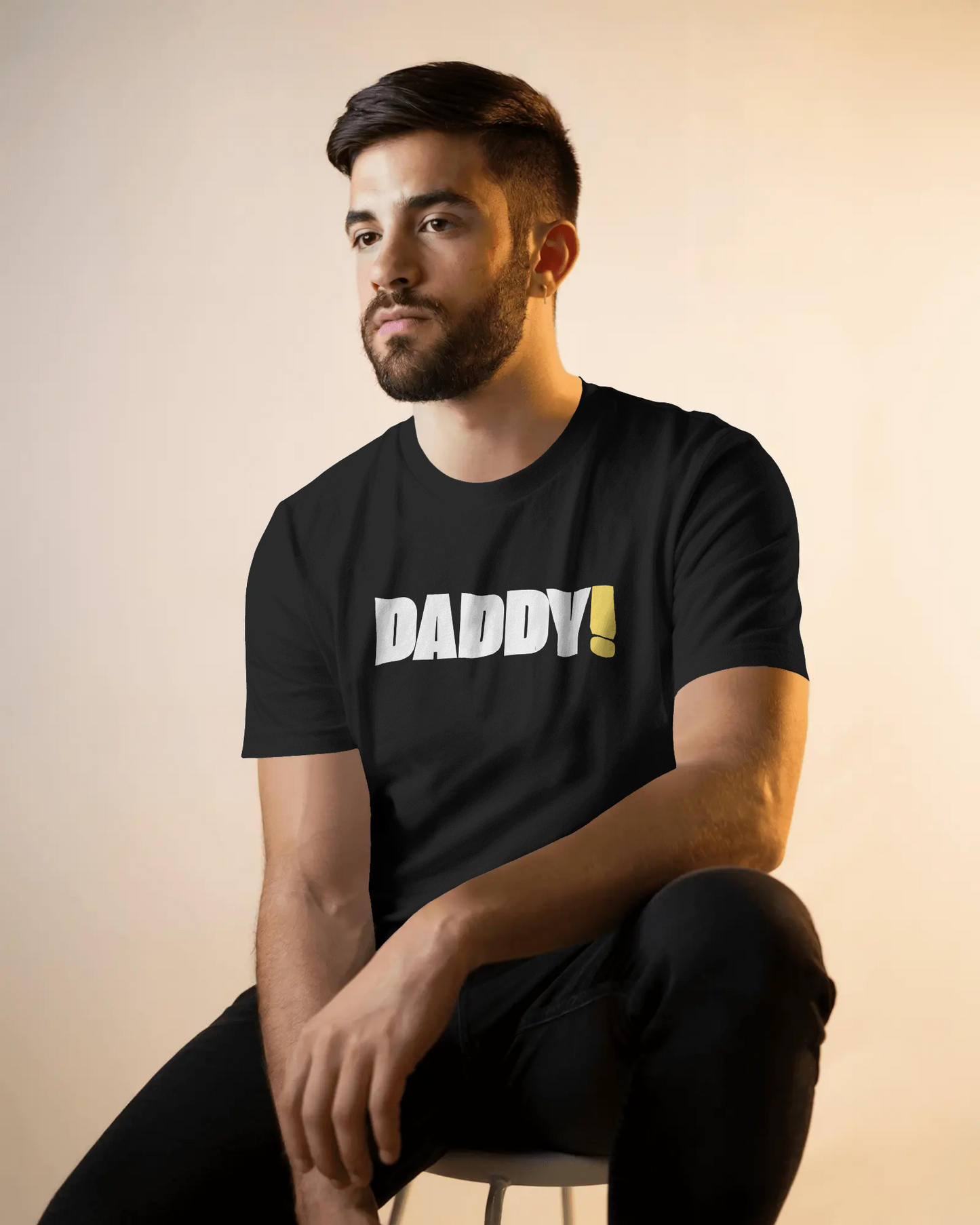 Man wearing a black t-shirt with 'DADDY!' text against a dark background LGBTQIA+ Kink Positive