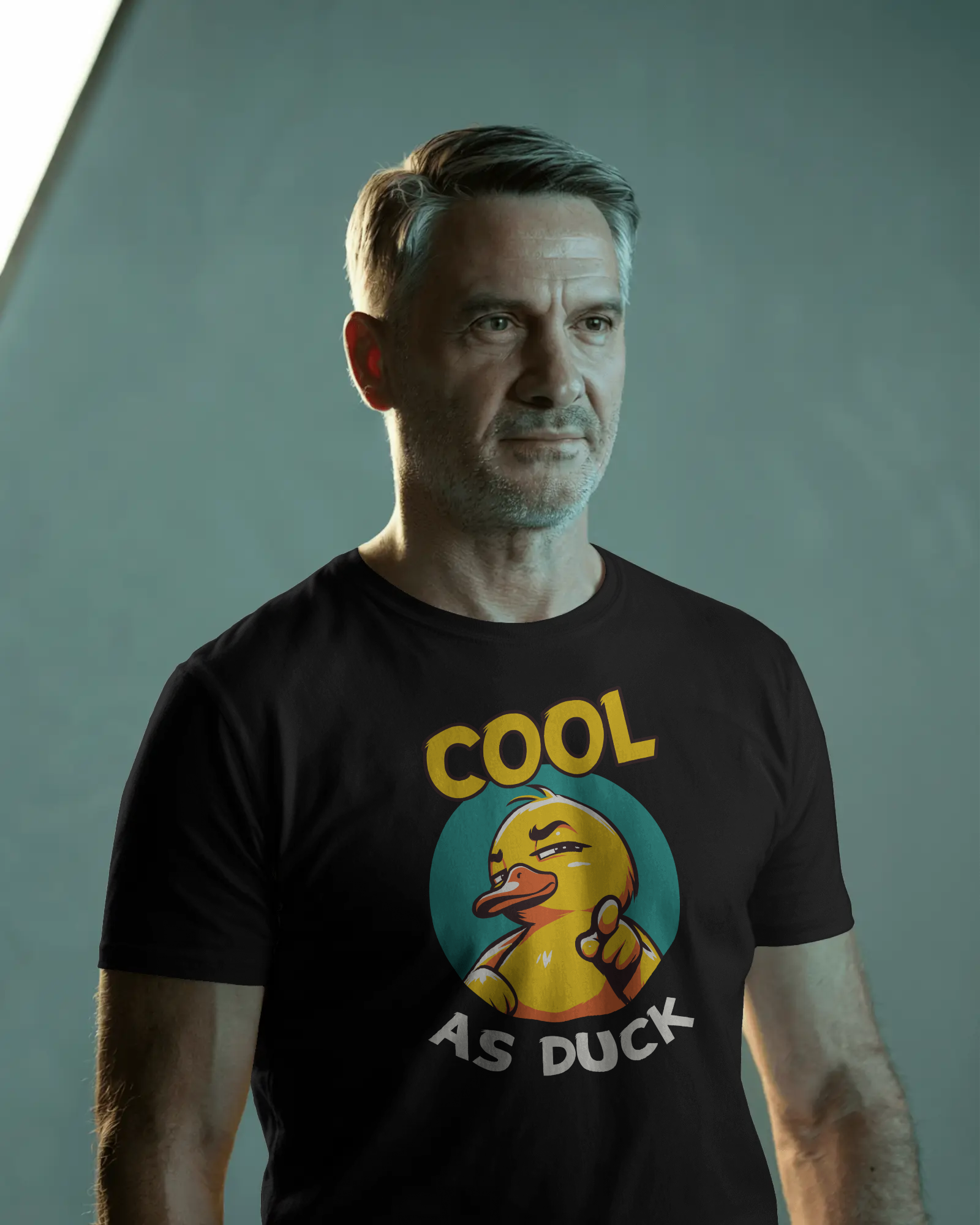 Man wearing a black t-shirt with a yellow duck graphic and text 'Cool as Duck' on a gray background