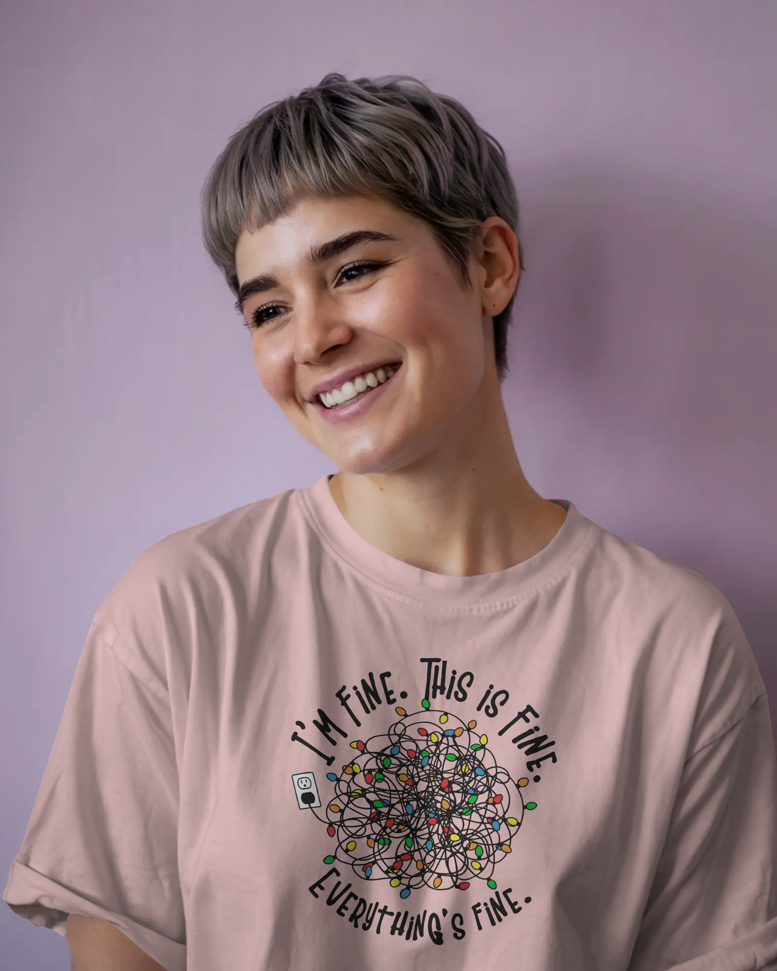 Person wearing a pink t-shirt with a colorful design of tangled Christmas Lights and the text "I'm fine, this is fine, everything is fine"