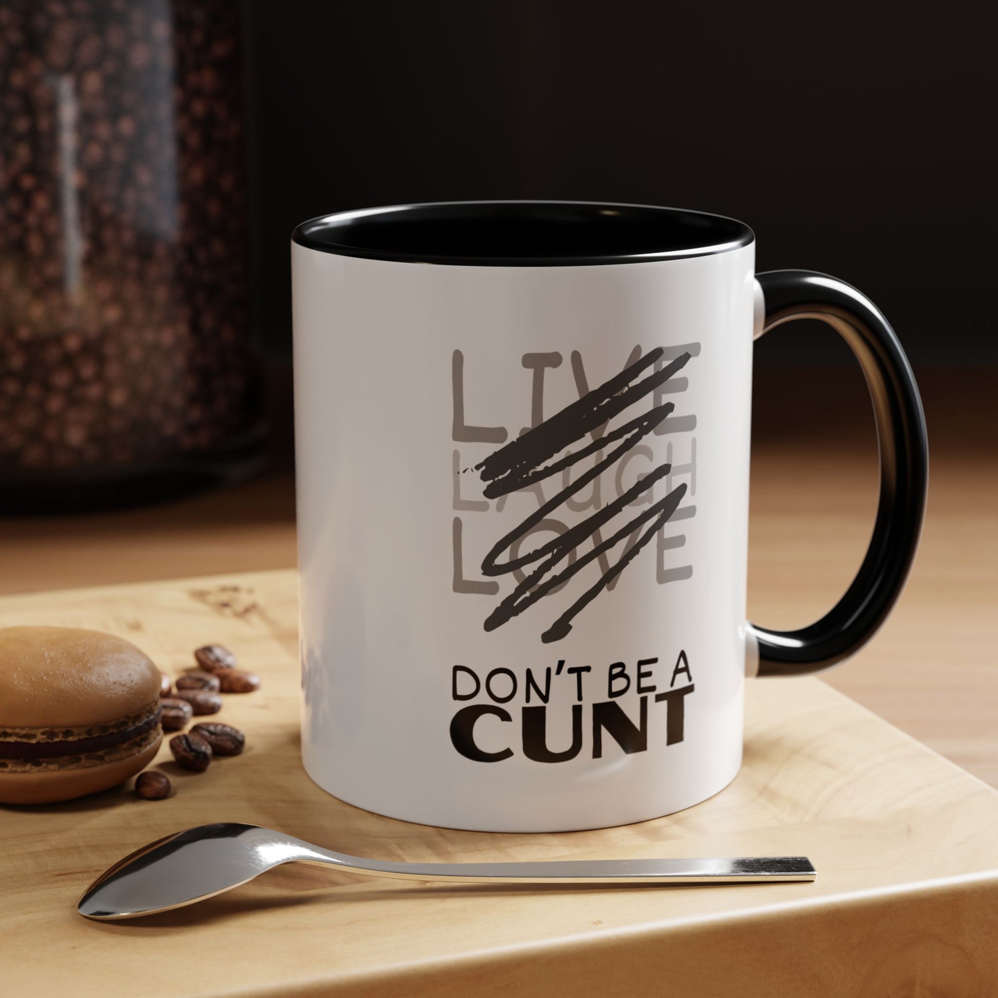 Mug with text on a wooden surface with coffee beans and a spoon