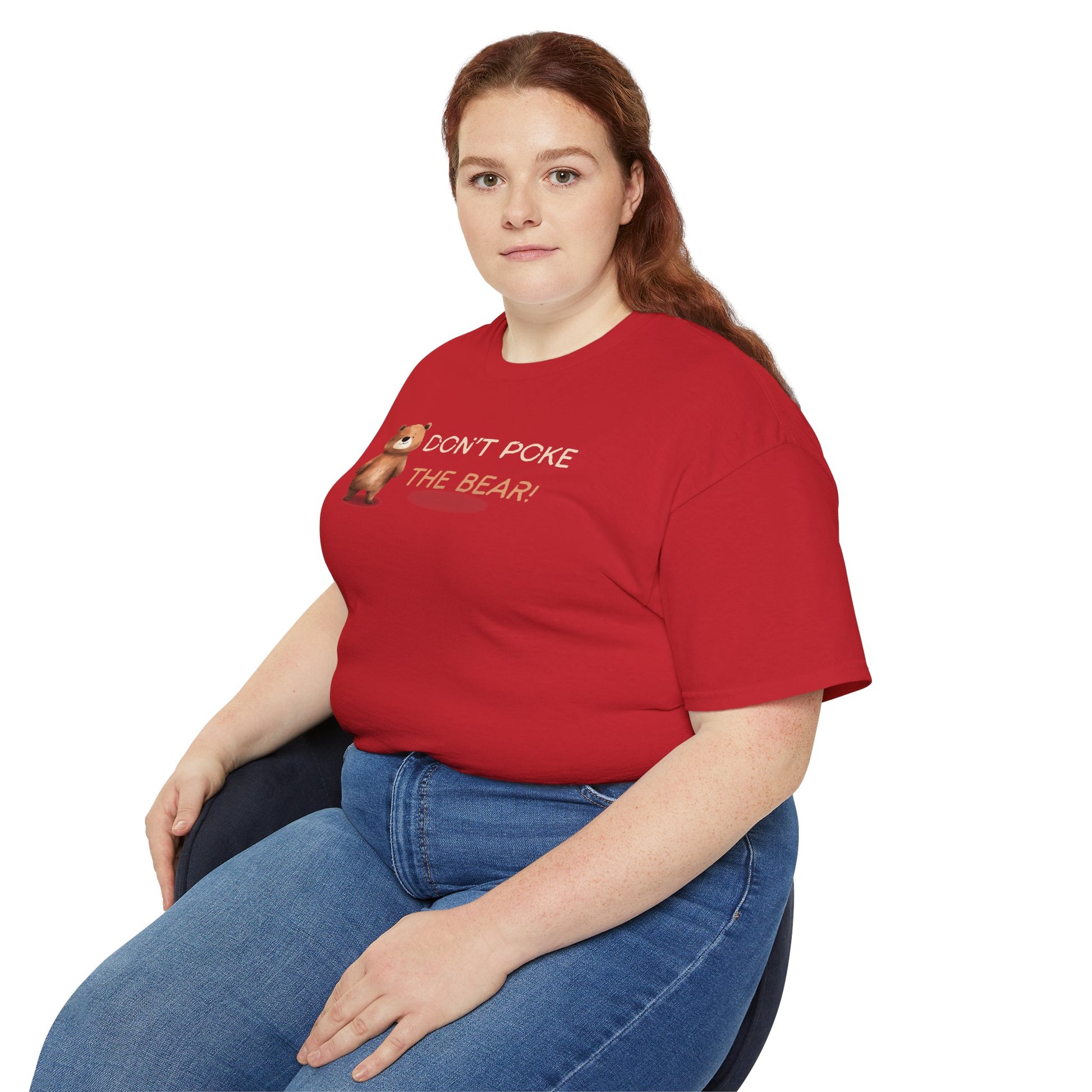 Person wearing a red t-shirt with a graphic and text, sitting on a white background