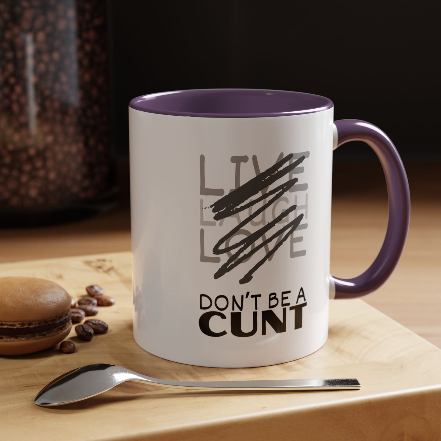 Mug with text on a wooden surface with coffee beans and a spoon